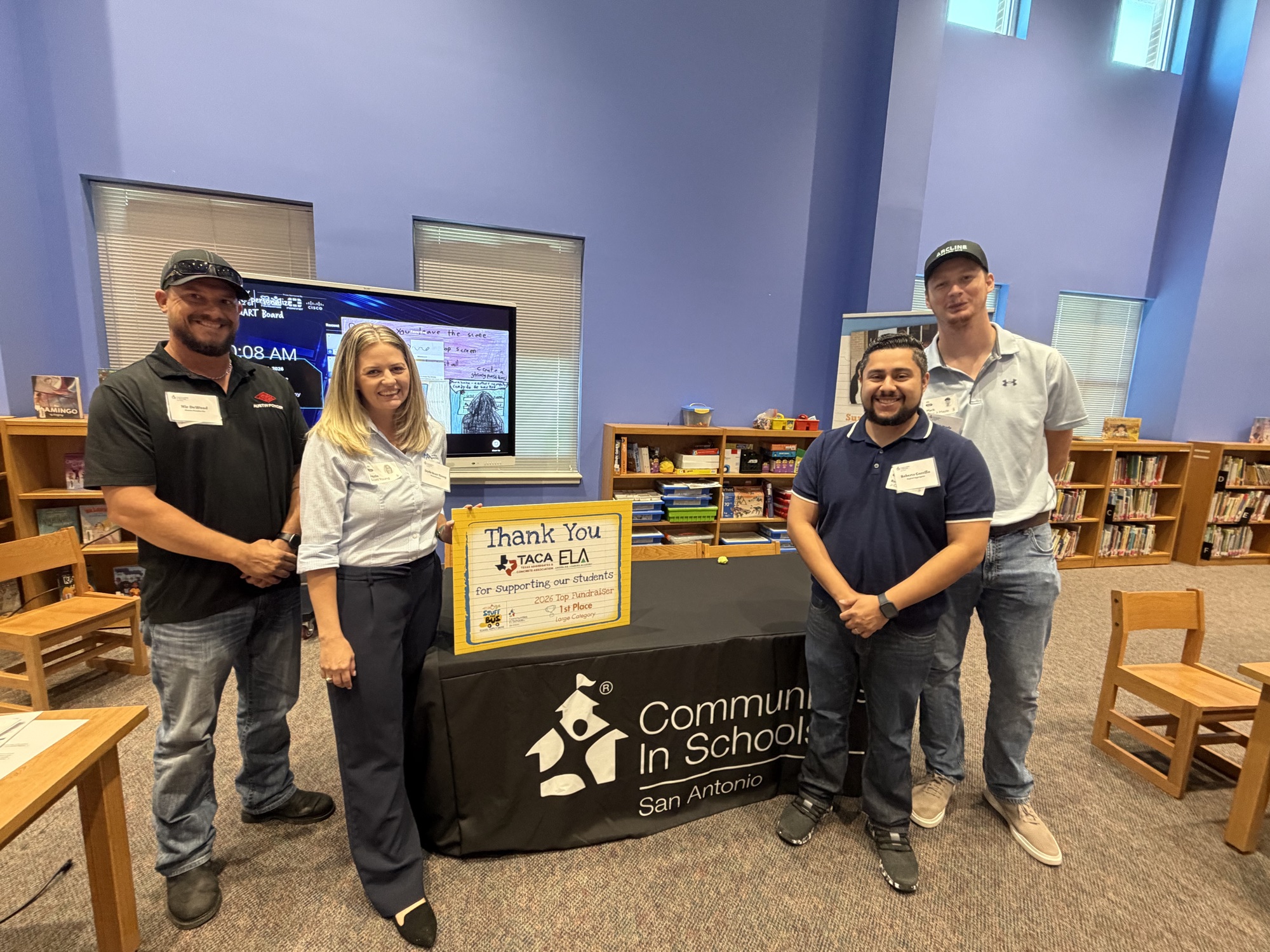 TACA Emerging Leaders Academy members Nic DeWood, Jayde Young, Roberto Carrillo and Mark Mayle with a thank-you sign from Communities In Schools of San Antonio at Margil Elementary School